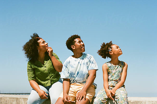 A mother and her two children look upward together, smiling